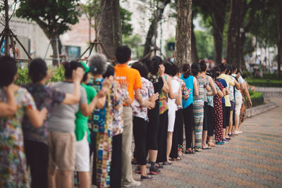 People waiting in line on footpath