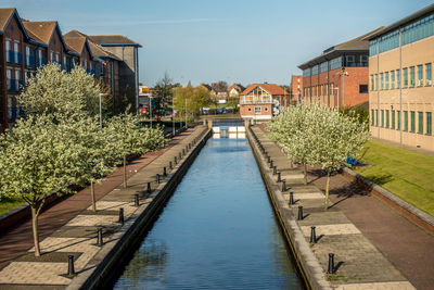 Canal amidst buildings against sky