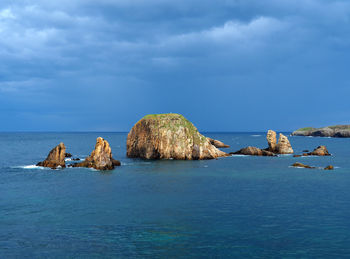 Rocks in sea against sky