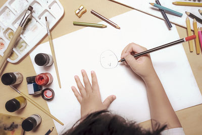 High angle view of woman hand on table