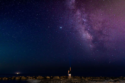 Rear view of man standing against star field against sky