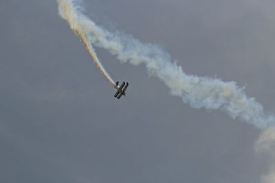 Low angle view of airplane flying against sky