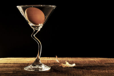 Close-up of wineglass on table against black background