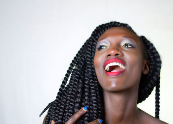 Portrait of young woman looking away against white background
