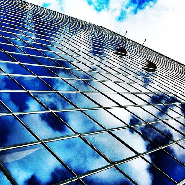 low angle view, architecture, built structure, building exterior, modern, office building, sky, glass - material, blue, reflection, building, pattern, tall - high, city, day, cloud - sky, tower, architectural feature, outdoors, window