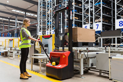 Rear view of woman standing in factory