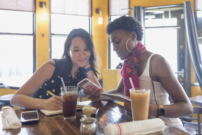 Young woman looking away while sitting in restaurant