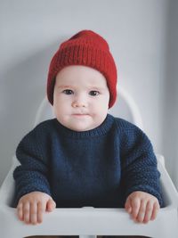 Portrait of cute baby boy sitting on high chair