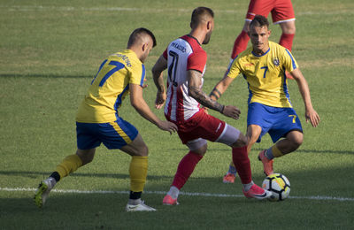 Group of people playing soccer on field