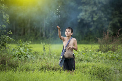 Boy throwing seeds on field