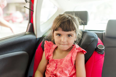 Small girl sitting in baby car seat