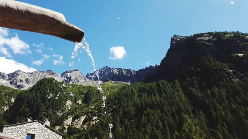 Low angle view of trees and mountains against sky