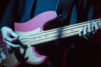 Midsection of man playing guitar