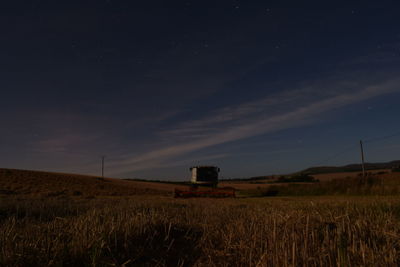 Scenic view of agricultural field against sky at dusk