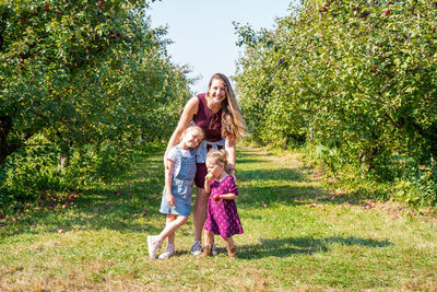 Full length of mother and daughter against trees