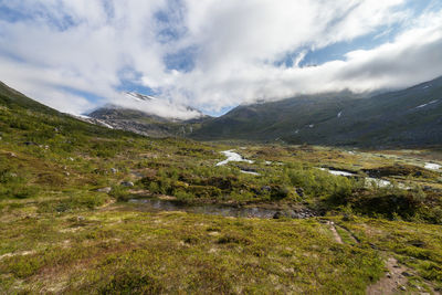 Scenic view of mountains against cloudy sky