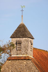 Cross on roof of building against clear sky