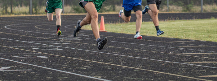 Panoramic view of runners legs flying along the track running in lanes