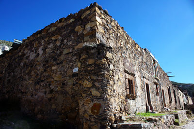 Low angle view of old building against clear blue sky