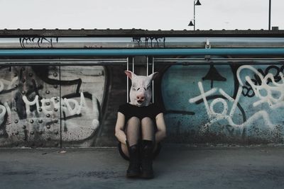 Full length of woman with graffiti on wall