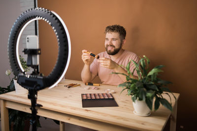 Young woman using mobile phone on table