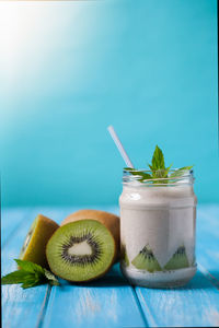 Kiwi fruits and smoothie jar on table