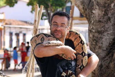 Man holding snake in city
