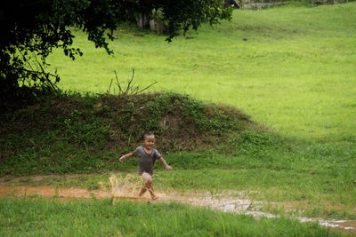 Full length of boy running on field