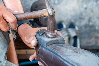 Close-up of person working on metal chain
