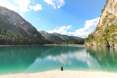 Scenic view of lake by mountains against sky