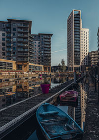 Boats moored at harbor in leeds dock with buildings in the background 