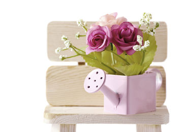 Close-up of pink rose on white table