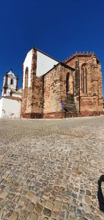 Low angle view of old building against clear blue sky