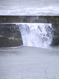 Scenic view of waterfall in sea