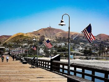 Empty benches on street against mountains and blue sky