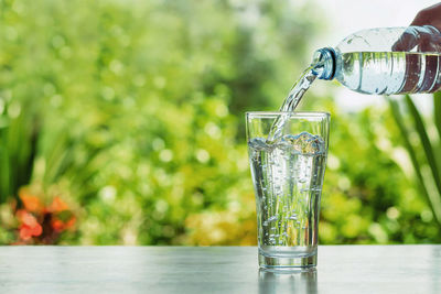 Close-up of glass pouring water on table