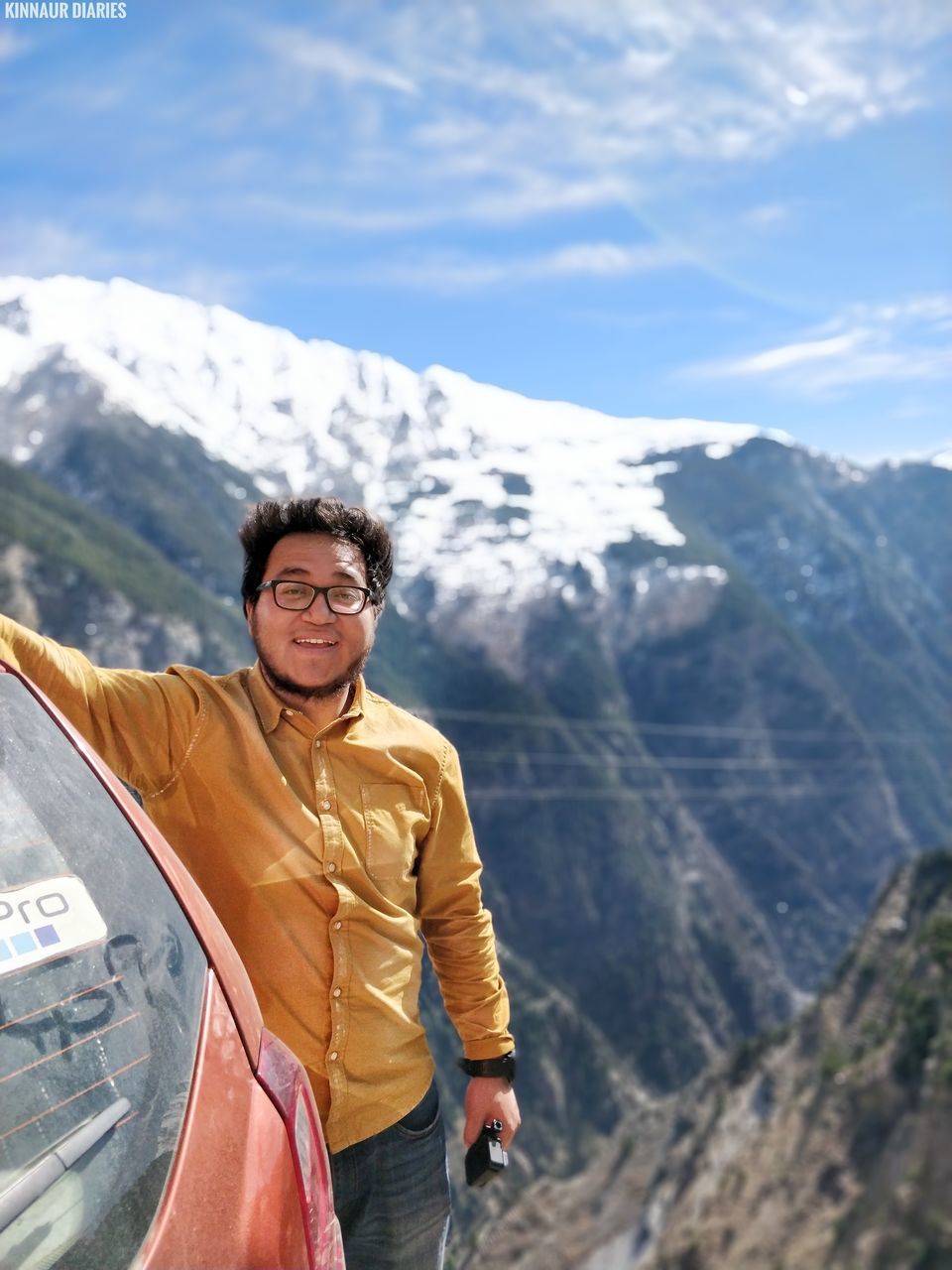 mountain, real people, lifestyles, young adult, smiling, happiness, nature, one person, leisure activity, mountain range, front view, looking at camera, day, outdoors, casual clothing, young men, standing, adventure, young women, portrait, sky, cheerful, beauty in nature, people