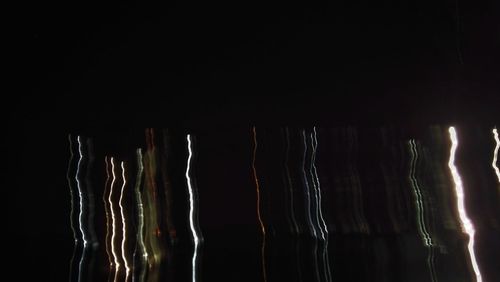 Close-up of illuminated lighting equipment against black background