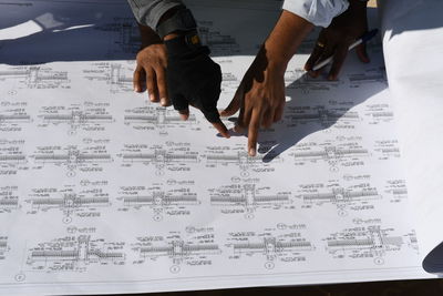 Cropped hands of architects looking at blueprint