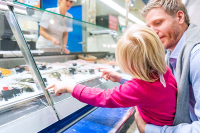 Rear view of mother with daughter in store