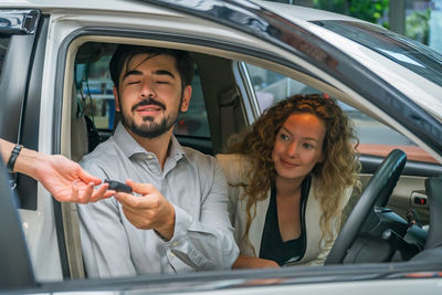 Portrait of young couple sitting in car