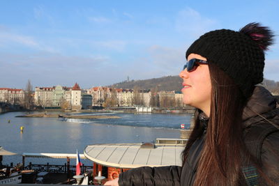 Woman with sunglasses against sky in city