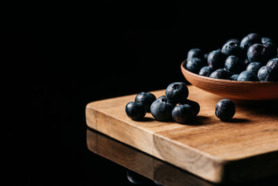 Close-up of fruits on table against black background