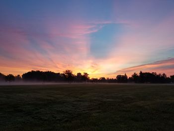 Scenic view of field against sky during sunset