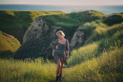 Rear view of woman walking on field