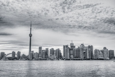 Modern buildings in city against cloudy sky