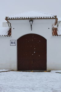 Closed door of snow covered building