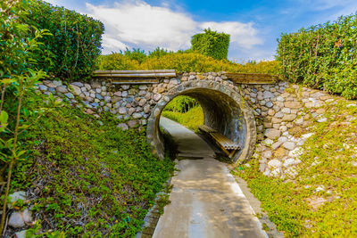 Arch bridge over canal against sky