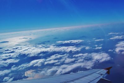 Cropped image of airplane flying over cloudscape