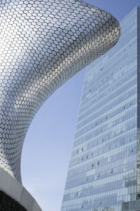 Low angle view of modern building against blue sky